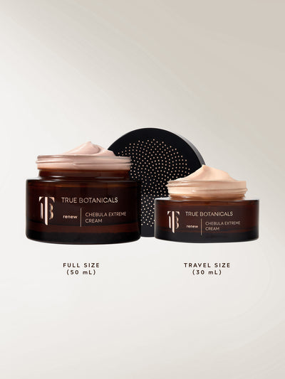 Two jars of True Botanicals Chebula Extreme Cream side by side, one labeled full size (50 mL) and the other travel size (30 mL). Both jars are amber glass with soft pink cream visibly swirled at the top. The background is neutral with a black, perforated lid placed behind the smaller jar.