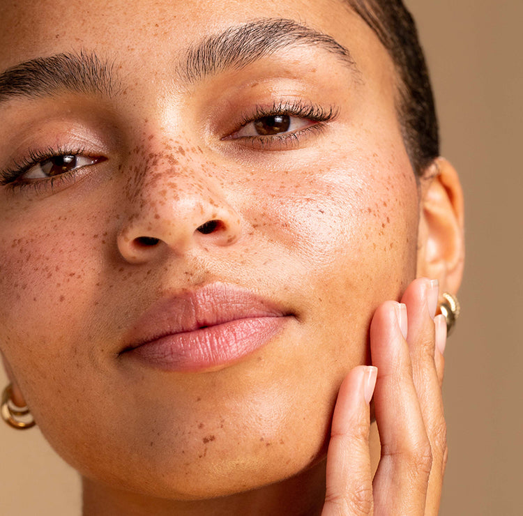 Model close up touching her cheeck