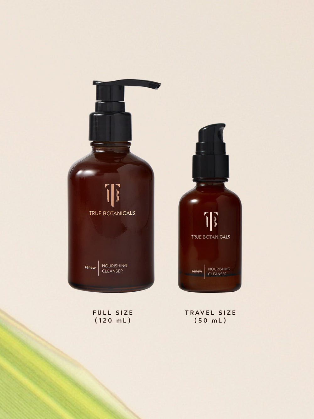 Two amber glass bottles of True Botanicals Renew Nourishing Cleanser shown side by side. The larger bottle with a pump dispenser is labeled full size (120 mL), and the smaller bottle with a similar pump is labeled travel size (50 mL). Both bottles feature minimalist gold branding on a neutral background.